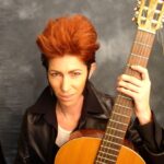 a picture of a person with a guitar and a dark background