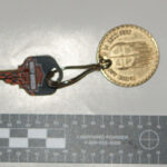 A picture of a key attached to a coin.