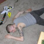a picture of a body laying on the floor with a guitar near him