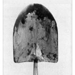 A picture of a dirty shovel close up.