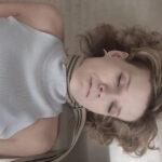 a picture of a blonde haired lady who has a rope tied around her neck.