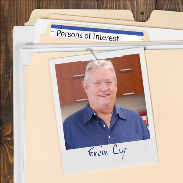 Manila folder with a photo of a smiling older man with silver hair clipped to it
