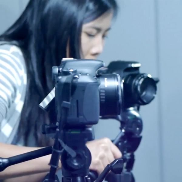 The director looks into the camera to line up her shot