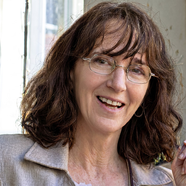 Smiling woman with glasses and shoulder-length dark hair