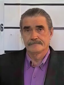 Older man with salt-and-pepper hair and mustache