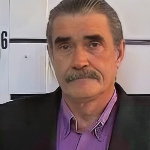 Older man with salt-and-pepper hair and mustache
