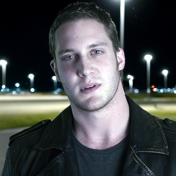 Tough-looking young man with short dark hair