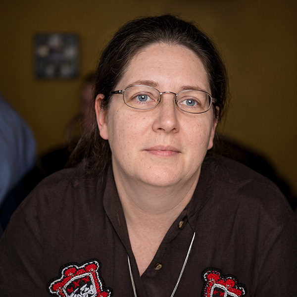 Woman with dark hair and glasses