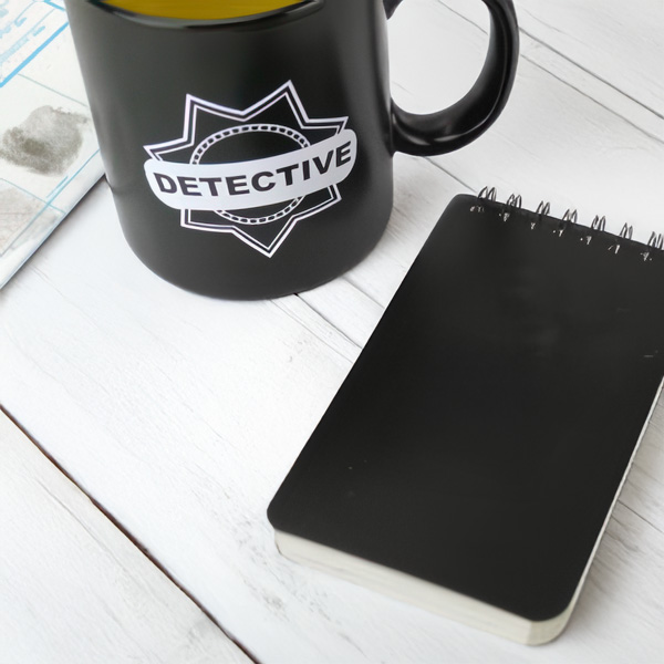 Detective coffee mug and a top spiral-bound notepad